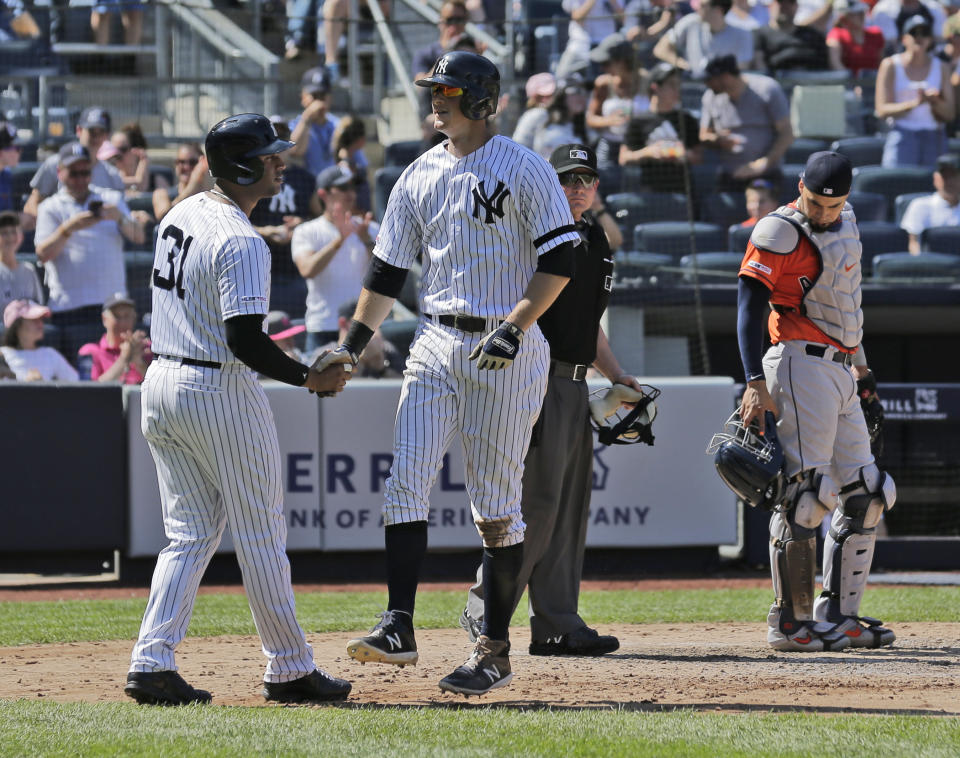 New York Yankees' DJ LeMahieu, second from left, celebrates his three-run home run with Aaron Hicks, left, while Houston Astros catcher Robinson Chirinos, right, looks on during the fifth inning of a baseball game at Yankee Stadium, Sunday, June 23, 2019, in New York. (AP Photo/Seth Wenig)