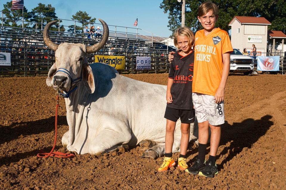 Leo and Kallum Hudson take a photo with Nucklehead at the rodeo at the Maury County Fair on Thursday, Aug. 31, 2023 in Columbia, Tenn.