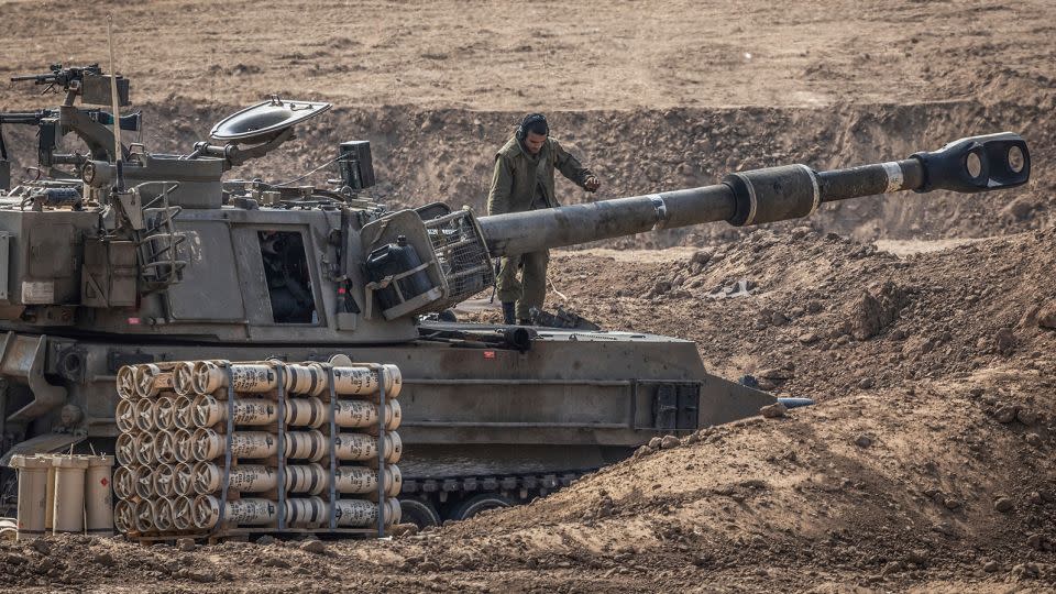 An Israeli soldier stands on artillery near the border with Gaza  on Saturday in Sderot, Israel. - Ilia Yefimovich/picture-alliance/dpa/AP