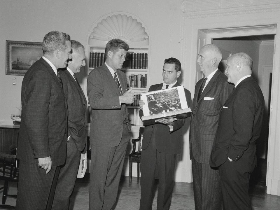 Stanley Tretick, UPI photographer on the Kennedy campaign, presents an album of pictures of the 1960 Kennedy campaign to President Kennedy at the White House.