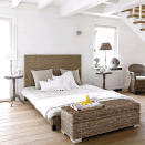<b>Seaside retreat</b><br><br>For a cool, seaside retreat, set natural materials against clean white walls. White wood panelling gives a beach-hut chic to the scheme, while plain bedlinen keeps the look crisp, clean and uncluttered – letting the beautiful rattan furniture take centre sage. The Hampton bed, chair, trunk and lampshade are all from <a href="http://www.maisonsdumonde.com/UK/en/produits/fiche/bed-hampton-110261.htm" rel="nofollow noopener" target="_blank" data-ylk="slk:Maisons du Monde;elm:context_link;itc:0;sec:content-canvas" class="link ">Maisons du Monde</a>. <br>