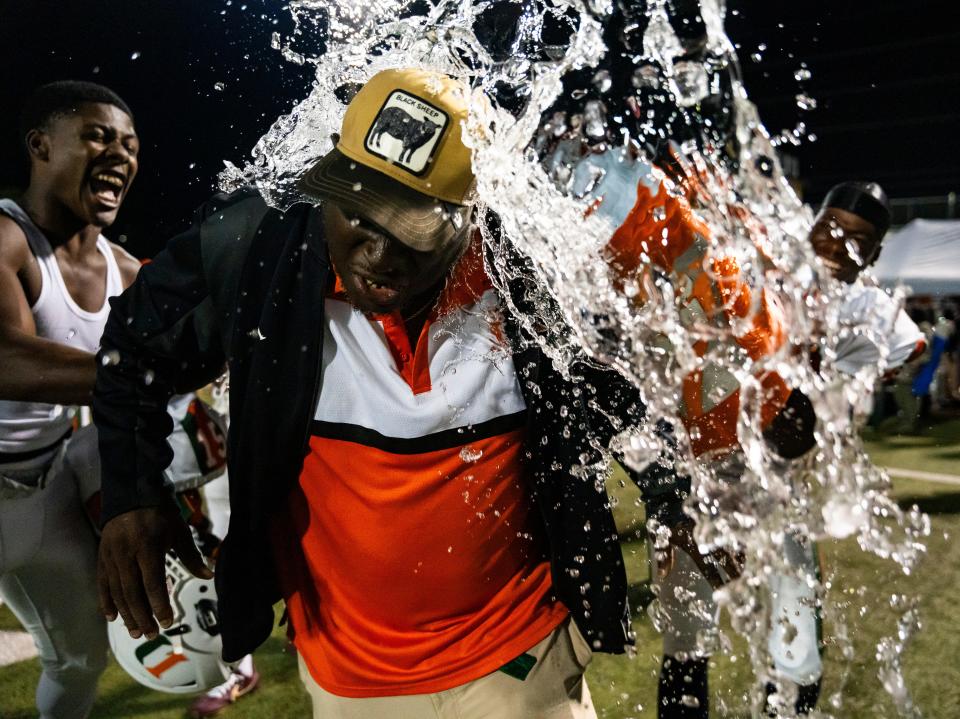 Dunbar Tigers head coach Sammy Brown has water dumped on him by players as they celebrate defeating the Naples Golden Eagles in the Class 3S regional championship at Staver Field in Naples on Friday, Nov. 24, 2023.