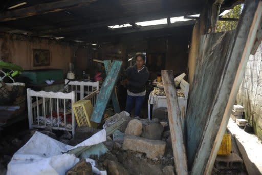 Una mujer trata de sacar escombros de su casa dañada por el terremoto, este jueves en San Marcos (Guatemala).
