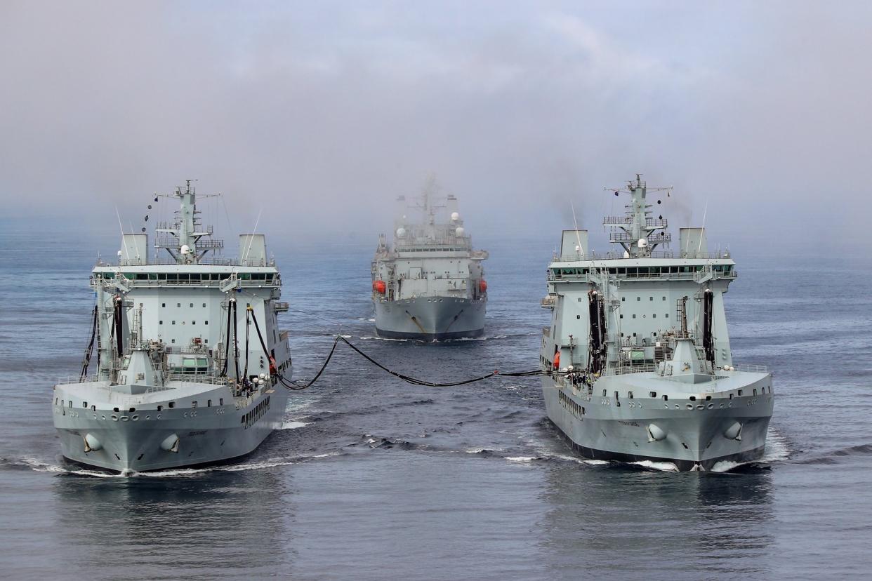 RFA Tidesurge, left, refuelling RFA Tideforce, right, at sea followed by RFA Fort Victoria (Crown Copyright/PA)
