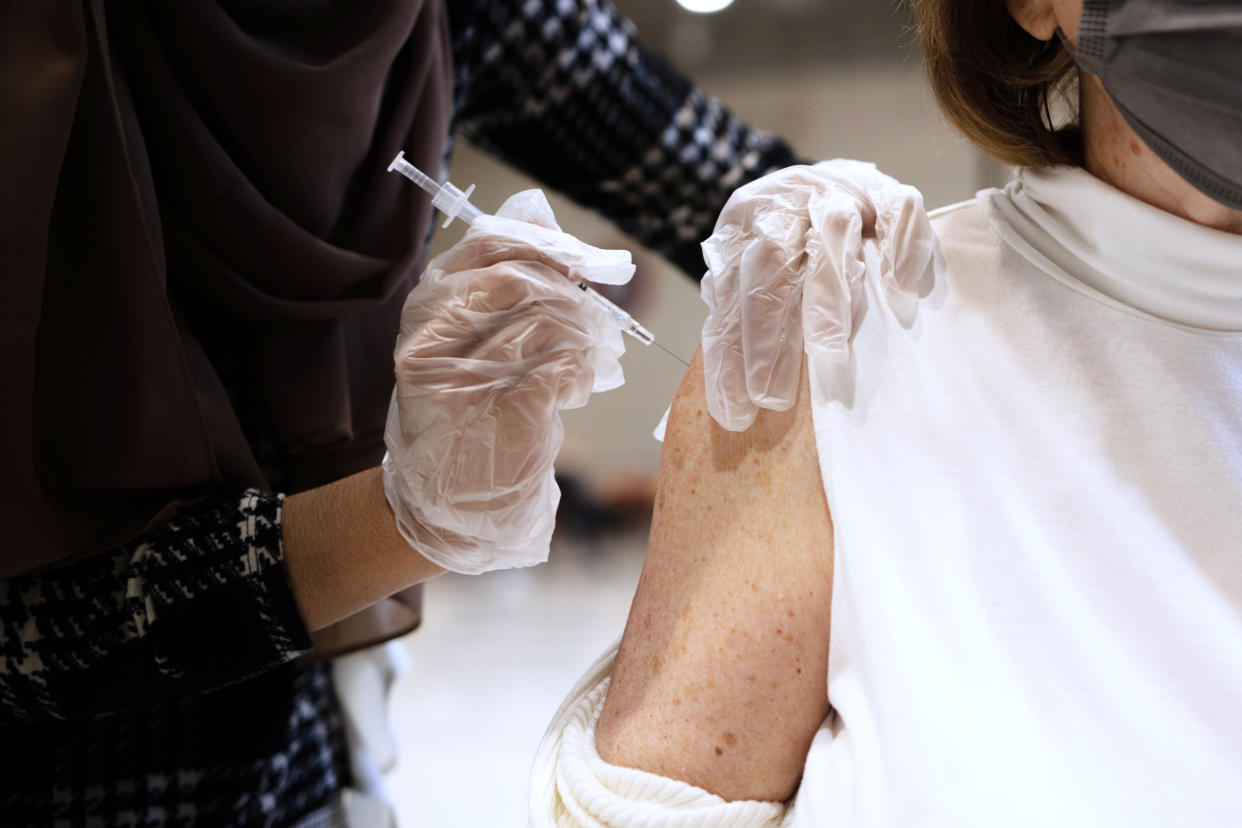 A person receives a Covid-19 booster shot ( Hannah Beier / Bloomberg via Getty Images file)