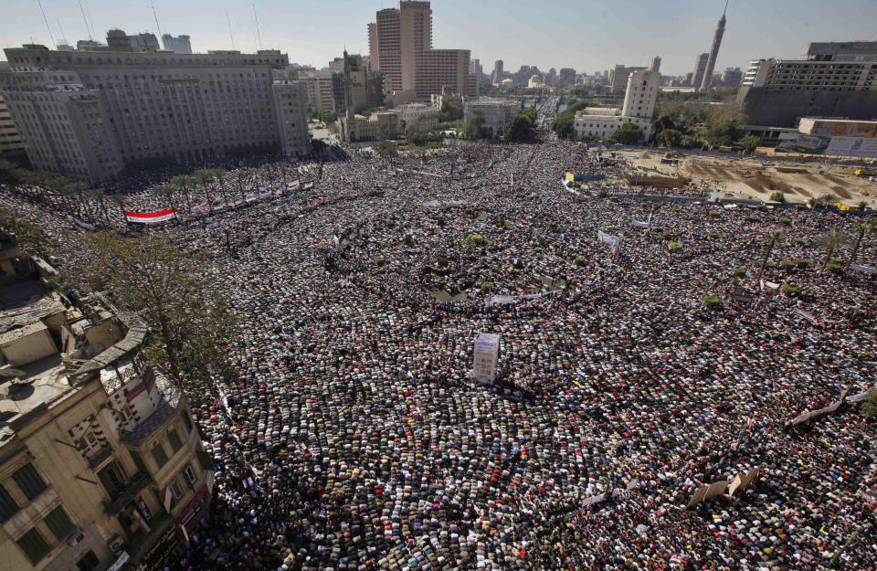 FILE - In this Feb. 18, 2011 file photo, Egyptians pray and celebrate the fall of the regime of former President Hosni Mubarak, and to maintain pressure on the current military rulers, in Tahrir Square in downtown Cairo, Egypt. The 2011 uprising led to the quick ouster of autocrat Mubarak. A decade later, thousands are estimated to have fled abroad to escape a state, headed by President Abdel Fattah el-Sissi, that is even more oppressive. (AP Photo/Ben Curtis, File)