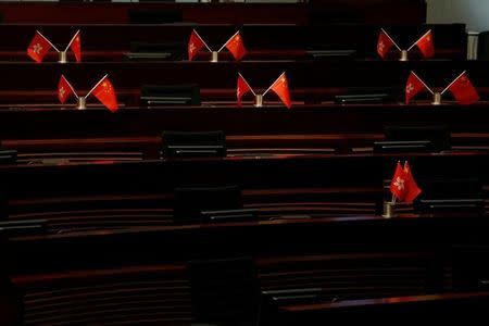 Empty seats with China and Hong Kong flags are seen inside a chamber after pro-Beijing lawmakers staged a walk-out to stall legislator-elects Baggio Leung and Yau Wai-ching from swearing in at the Legislative Council in Hong Kong, China October 19, 2016. REUTERS/Bobby Yip