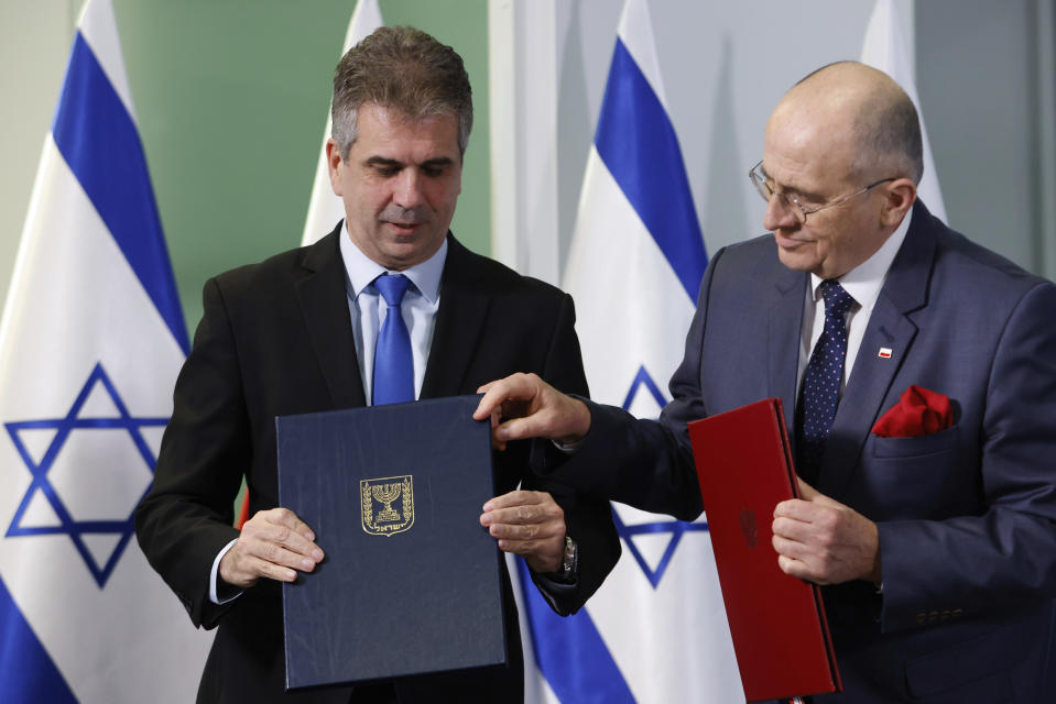 Poland's Minister of Foreign Affairs Zbigniew Rau, right, and his Israeli counterpart Eli Cohen, left, pose for a picture after signing an agreement allowing the resumption of Israeli youth trips to Poland in Warsaw, Poland, Wednesday, March 22, 2023. (AP Photo/Michal Dyjuk)