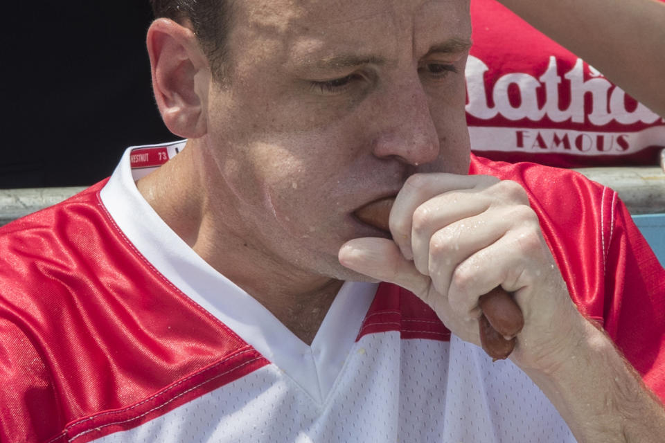 <p>Reigning champion Joey Chestnut eats two hot dogs at a time during the men’s competition of the Nathan’s Famous Fourth of July hot dog eating contest, Wednesday, July 4, 2018, in New York’s Coney Island. Defending champion Joey Chestnut broke his own world record by eating 74 hot dogs in 10 minutes. (Photo: Mary Altaffer/AP) </p>