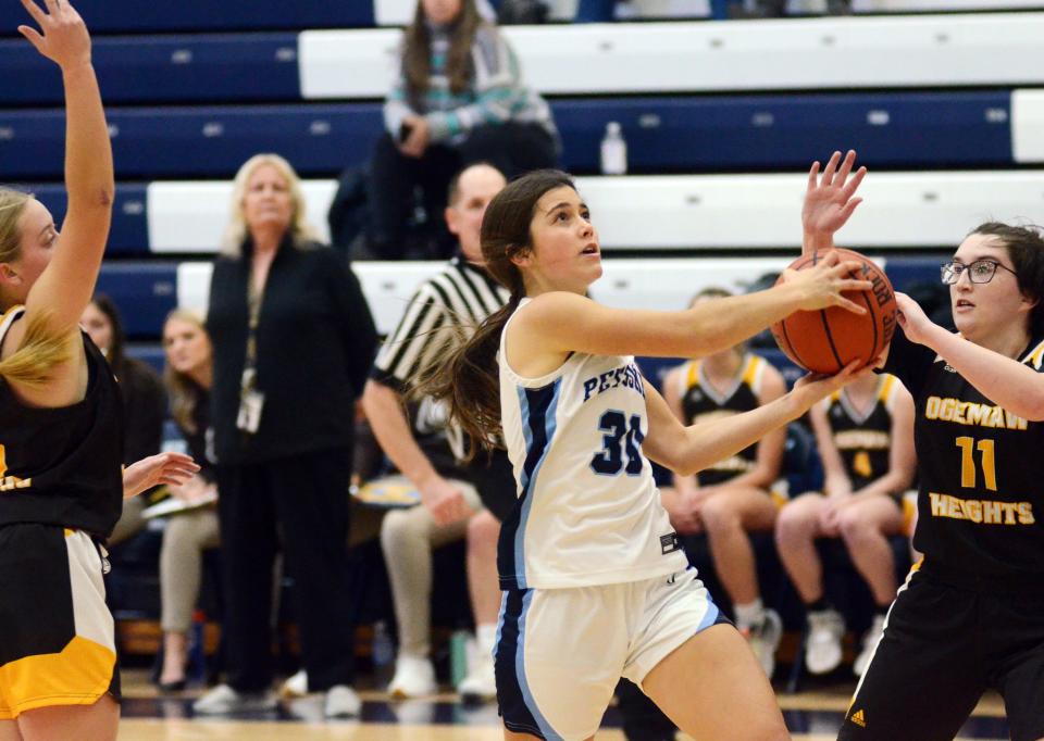 Petoskey guard Ellie Stolzenfels drives around a pair of Ogemaw defenders for a finish at the rim Tuesday.