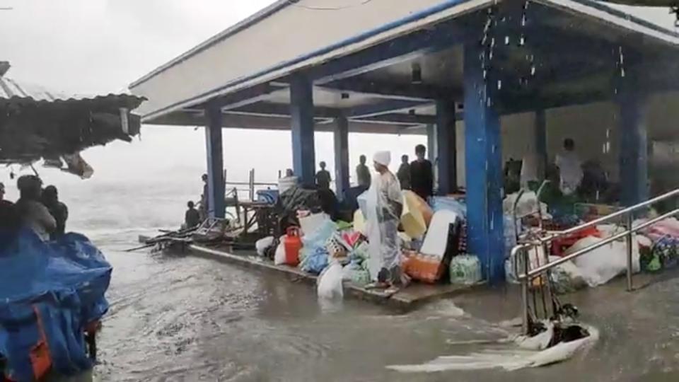 People stand in cover on a flooded market as Super Typhoon Surigae moves close to the Philippines in the province of CatbaloganDJ RJ RENE CASTINO via REUTERS