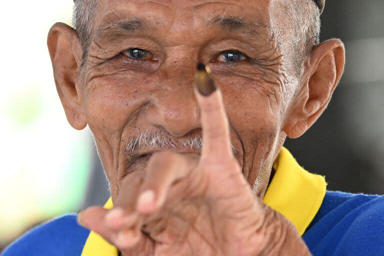 Un recluso muestra su dedo marcado después de votar durante las elecciones presidenciales y legislativas de Indonesia en una estación de votación en la prisión de Banda Aceh el 14 de febrero de 2024.