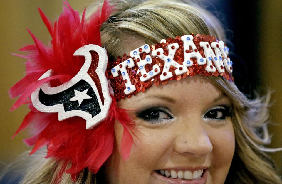 Houston Texans fan Rachel Mitchamore smiles as she waits for the start of the NFL draft while attending a Houston Texans draft day party at NRG Stadium Thursday, May 8, 2014, in Houston. The Texans have the first pick in the NFL draft. (AP Photo/David J. Phillip)