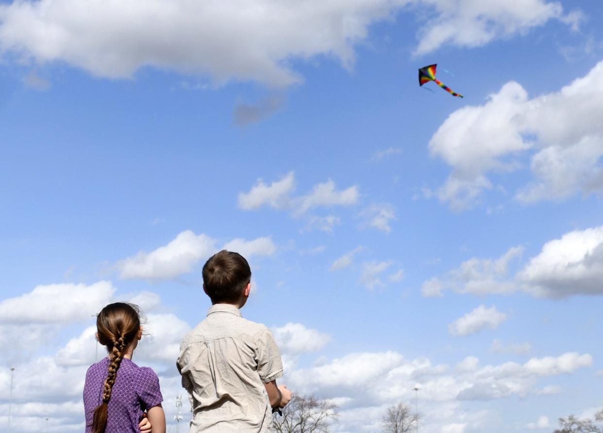 Easton Kauffman, 11 and sister, Felicity, 9 hold tight to a kite on a very warm and very windy day during a familey outing at Weis Park in Canton.  Thursday,  February 23, 2023.