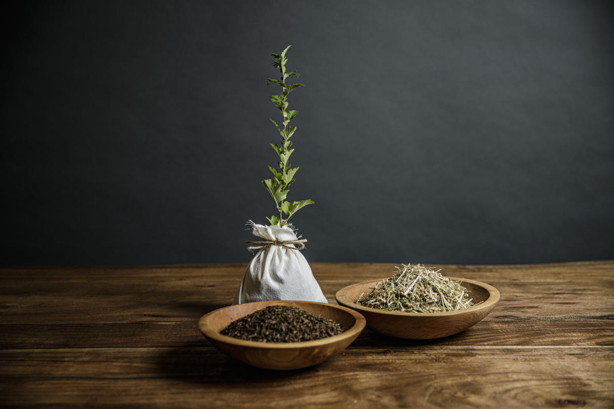 Two wooden bowls on a table hold human composted soil and the plant-based mix that’s put in the vessel as part of the composting process.