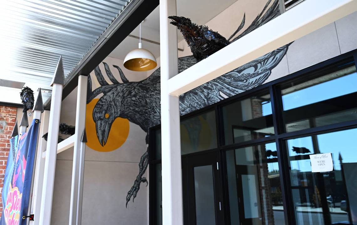 A mural of a crow is seen along with metal sculptures of crows at the entrance to the Sun Stereo Warehouse, a former historical Ford dealership that’s been renovated into a business and art hub on Fulton Street Thursday, Aug. 18, 2022 in downtown Fresno.