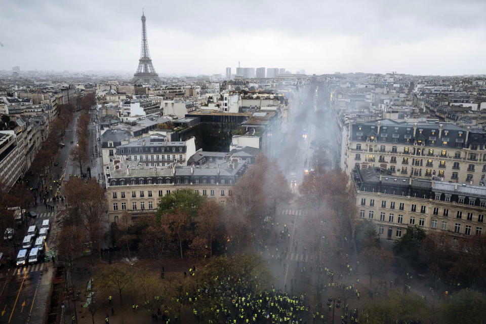 Demonstrators are pictured from the top of the Arc de Triomphe on the Champs-Elysees avenue during a demonstration Saturday, Dec.1, 2018 in Paris. Demonstrations against rising taxes turned into scenes of rioting in Paris city center as at least 65 people including 11 police officers have been injured in violent protests in the French capital. (AP Photo/Kamil Zihnioglu)