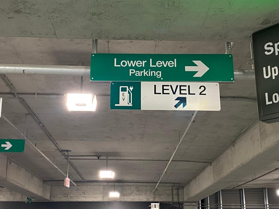This brand-new parking structure has six level 2 240v electric car chargers, but no outside signs telling drivers how to find them.