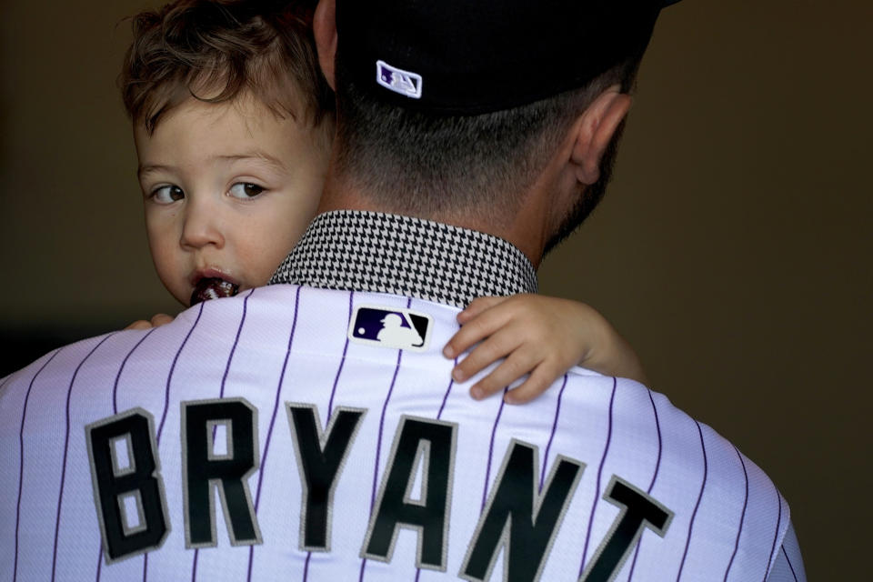 Colorado Rockies' Kris Bryant leaves with his son, Kyler, 2, after being introduced by the baseball team for the first time, Friday, March 18, 2022, in Scottsdale, Ariz. (AP Photo/Matt York)