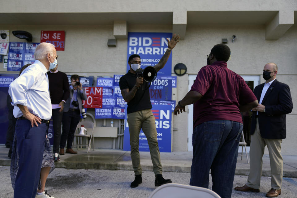 FILE - Miami Heat player Udonis Haslem speaks as then-Democratic presidential candidate former Vice President Joe Biden, left, appears outside a campaign victory center, Thursday, Oct. 29, 2020, in Fort Lauderdale, Fla. Every NBA team is doing something to get ready for Election Day on Tuesday. It just might not be as amplified as it seemed two years ago. (AP Photo/Andrew Harnik, File)