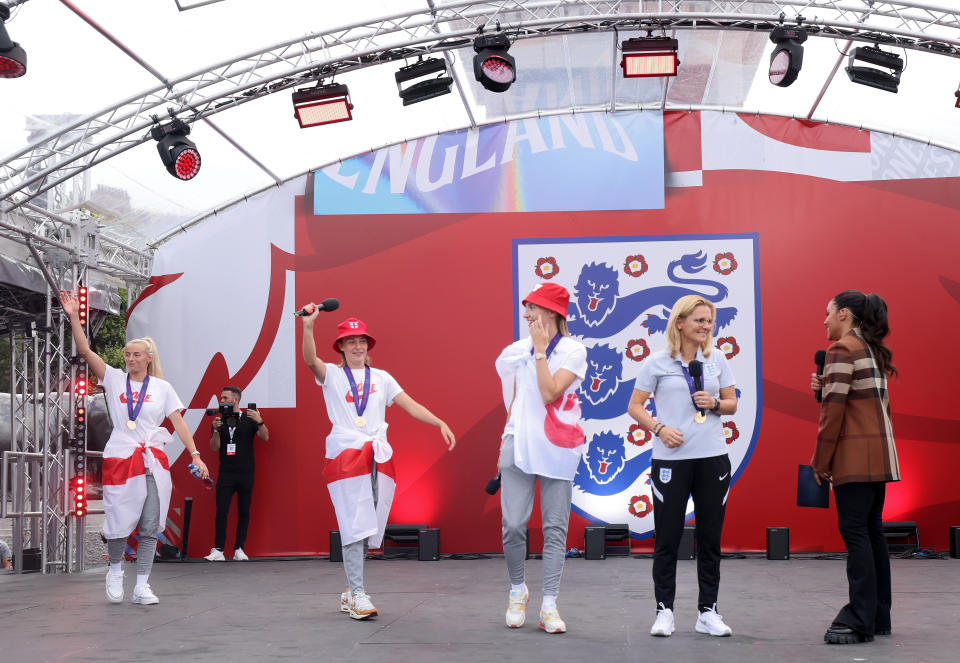 England's Chloe Kelly, Ella Toone, Leah Williamson and head coach Sarina Wiegman speaking to presenter Alex Scott on stage during a fan celebration to commemorate England's historic UEFA Women's EURO 2022 triumph in Trafalgar Square, London. Picture date: Monday August 1, 2022.