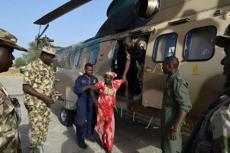 Rescued Chibok schoolgirl Amina Ali Darsha Nkeki is helped from a military helicopter in Maiduguri, Nigeria in this handout received May 19, 2016. Nigeria Military/Handout via REUTERS