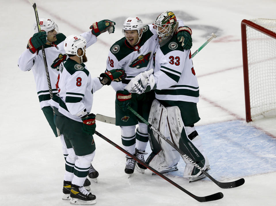 From left to right, Minnesota Wild's Marcus Foligno (17), Jordie Benn (8), Dmitry Kulikov (29) and Cam Talbot (33) celebrate their victory over the New York Rangers in an NHL hockey game Friday, Jan. 28, 2022, in New York. (AP Photo/John Munson)