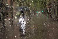 A primary care physician walks to visit a patient during a rainfall in Barcelona, Spain, April 21, 2020, as the lockdown to combat the spread of coronavirus continues. (AP Photo/Emilio Morenatti)