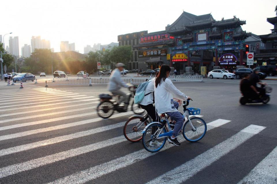 Cyclists in the 'Ancient Culture' district of Tianjin, China (UKRI ESRC )