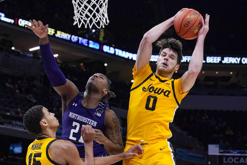 FILE - Iowa forward Filip Rebraca (0) grabs a rebound over Northwestern forward Elyjah Williams (21) in the second half of an NCAA college basketball game at the Big Ten Conference tournament in Indianapolis, Thursday, March 10, 2022. Iowa coach Fran McCaffery says Filip Rebraca should increase his scoring with a move from the traditional center's spot. (AP Photo/Michael Conroy, File)