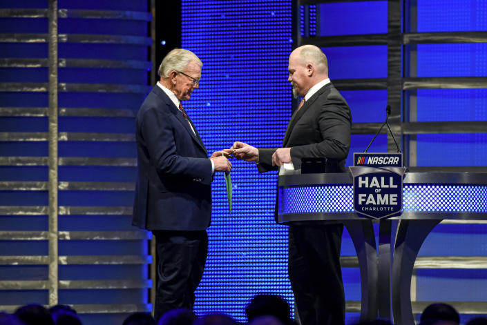 FILE - Coy Gibbs, right, presents the Hall of Fame ring to his father, NASCAR Hall of Fame inductee Joe Gibbs, during the induction ceremony in Charlotte, N.C., on Jan. 31, 2020. Coy, the vice chairman at Joe Gibbs Racing for his NFL and NASCAR Hall of Fame father, died Sunday morning, Nov. 6, 2022. He was 49. His death came just hour after his son Ty won the Xfinity Series championship. (AP Photo/Mike McCarn, File)