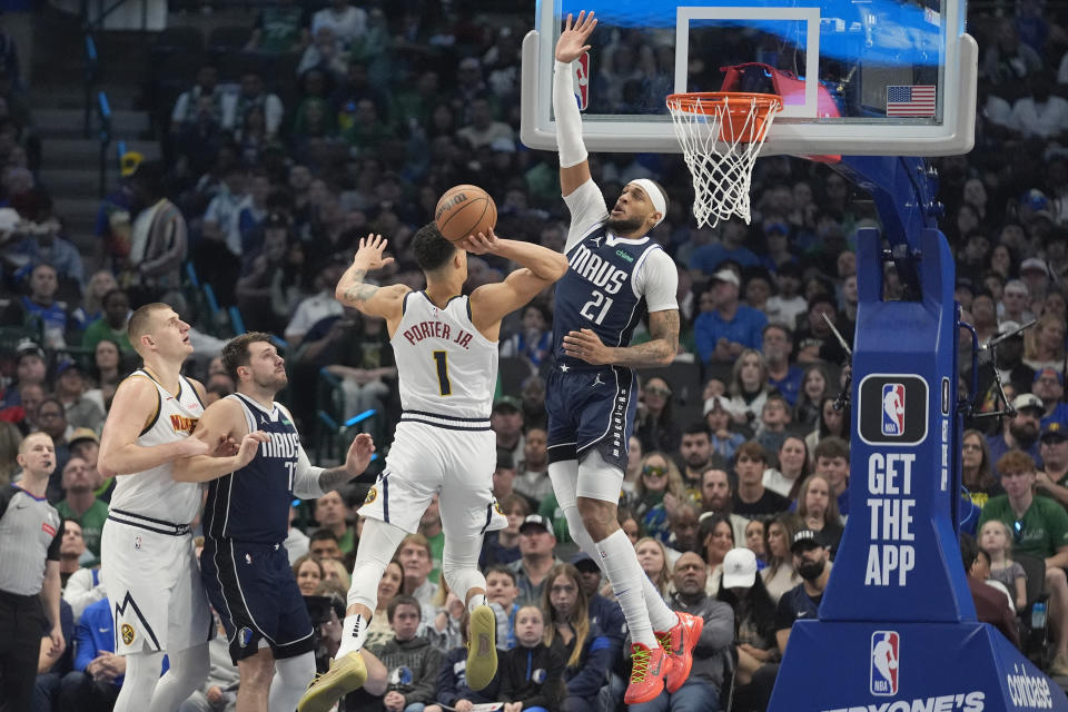 Denver Nuggets forward Michael Porter Jr. (1) drives to shoot against Dallas Mavericks center Daniel Gafford (21) as Mavericks' guard Luka Doncic (77) and Nuggets' center Nikola Jokic look on during the first half of an NBA basketball game in Dallas, Sunday, March 17, 2024. (AP Photo/LM Otero)