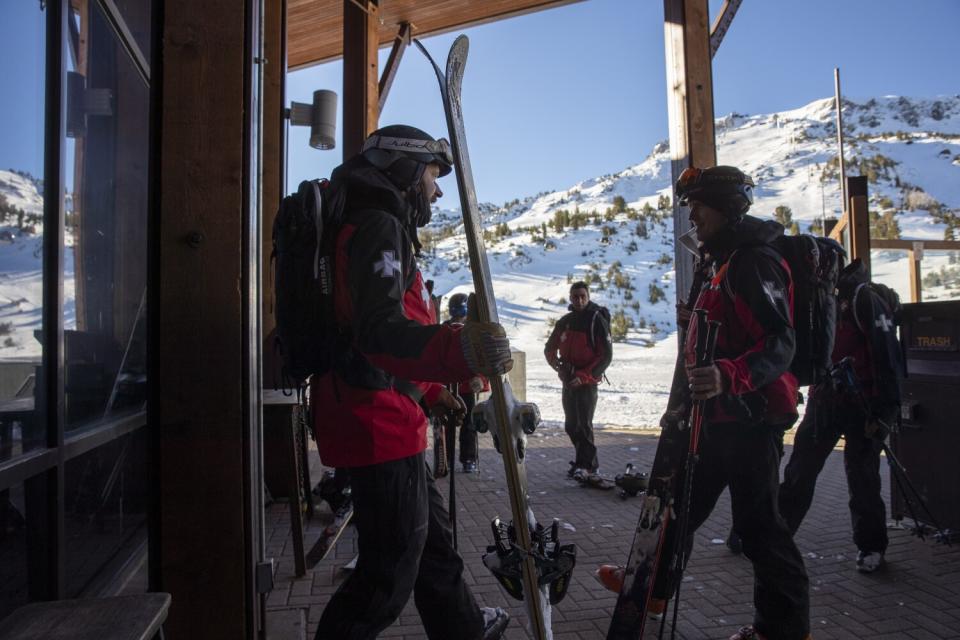 Mammoth Mountain ski patrol members head out from the summit to ready the slopes