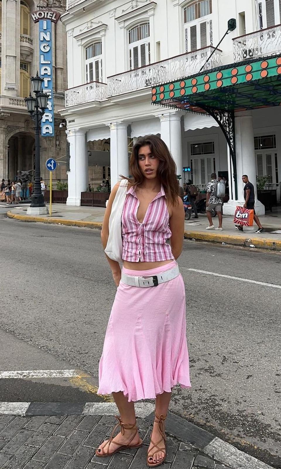 falda midi rosa pastel con top camisero de rayas y cinturon en la cadera