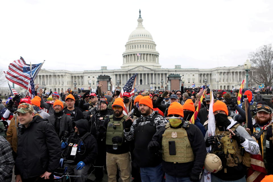 Members of the far-right group Proud Boys make the OK hand gesture while standing in front of the Capitol on January 6, 2021.