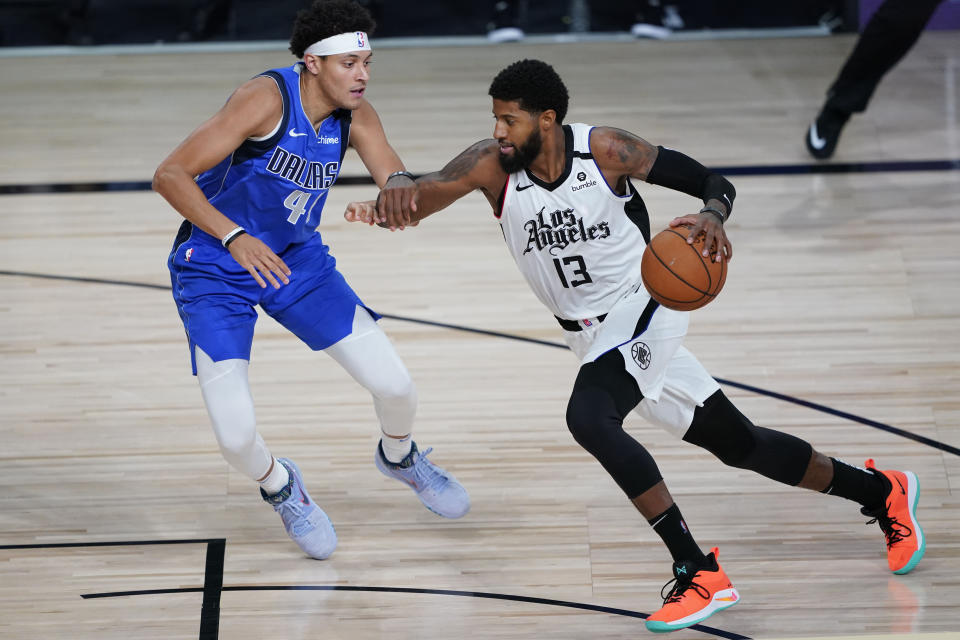 Los Angeles Clippers' Paul George (13) drives to the basket against Dallas Mavericks' Justin Jackson (44) during the second half of an NBA basketball first round playoff game Tuesday, Aug. 25, 2020, in Lake Buena Vista, Fla. (AP Photo/Ashley Landis, Pool)
