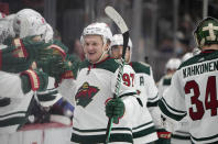Minnesota Wild left wing Kirill Kaprizov is congratulated as he passes the team box after scoring a goal in the third period of an NHL hockey game against the Colorado Avalanche, Monday, Jan. 17, 2022, in Denver. (AP Photo/David Zalubowski)