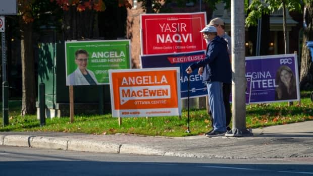 Two people walk through the federal riding of Ottawa Centre this past week, the final one of the 2021 federal election campaign.  (Francis Ferland/CBC - image credit)