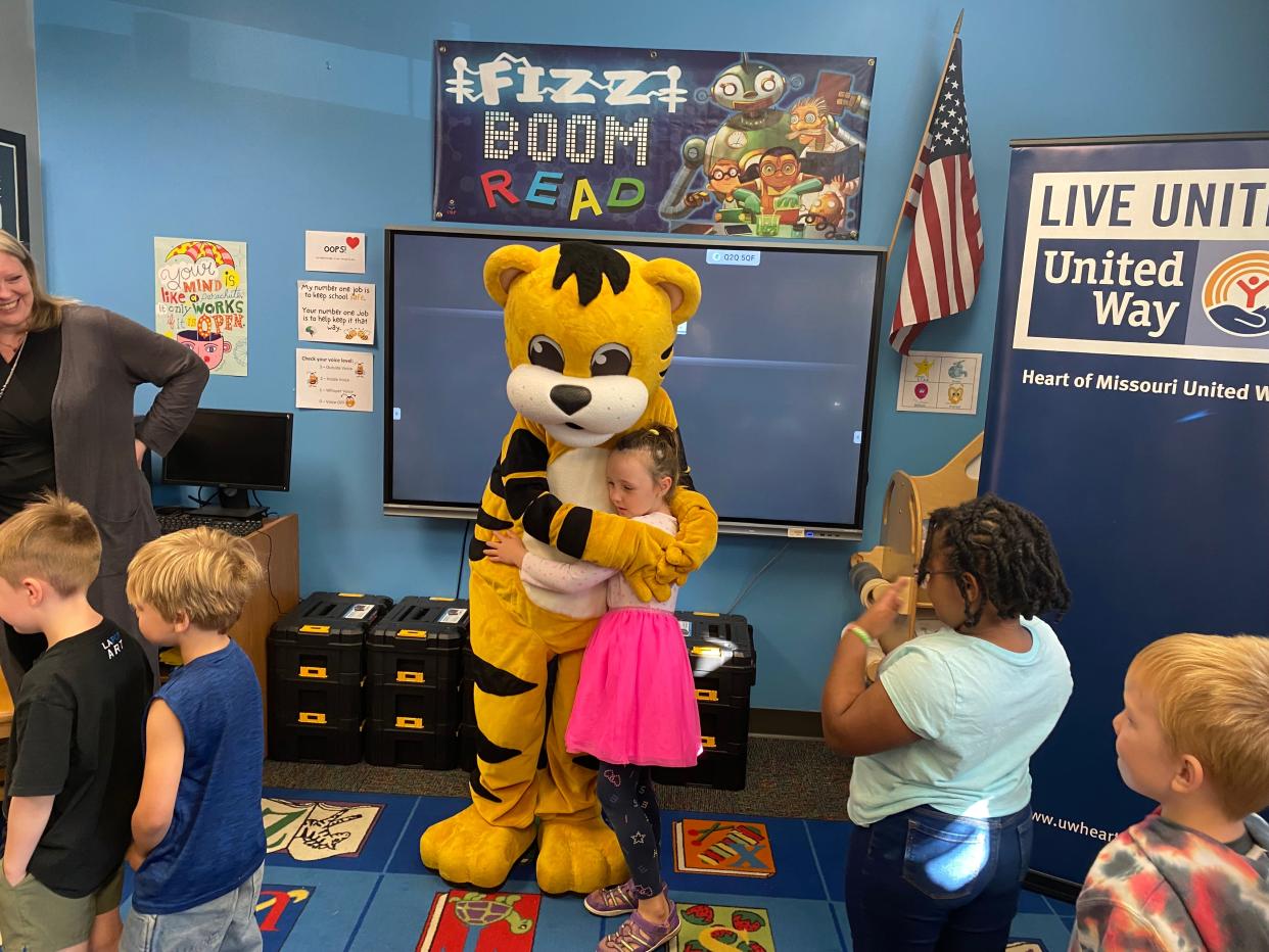 Benton STEM Elementary School first-grader Delaney Oldfather on Wednesday hugs the University of Missouri kids' mascot, TJ, during United Way's Read Across Columbia event at the school.