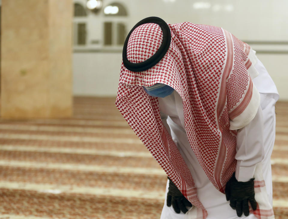 A Saudi worshipper wearing a face mask and gloves as he prays dawn prayers at al-Mirabi Mosque in Jiddah, Saudi Arabia, Sunday, May 31, 2020. The Ministry of Islamic Affairs said mosques will open to the public for prayers from May 31 until June 20, except in Mecca, with precautionary measures and instructions. (AP Photo/Amr Nabil)