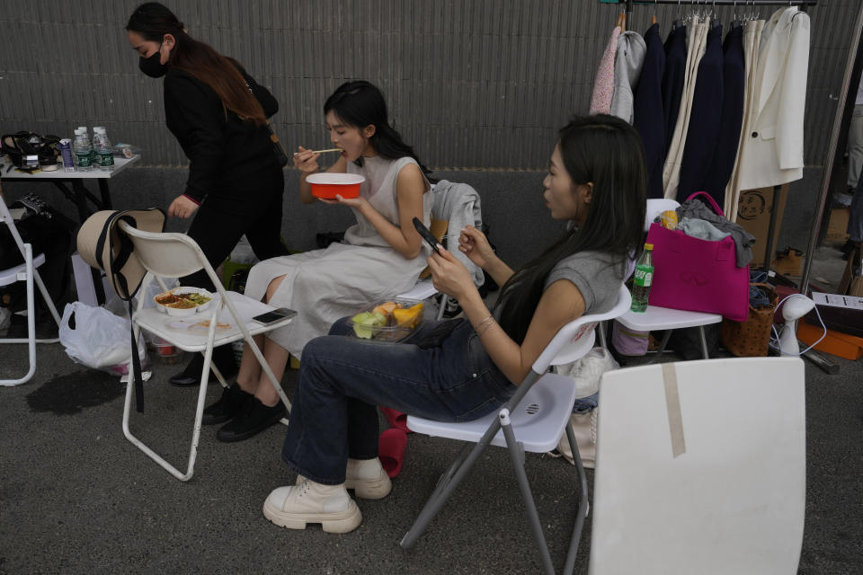 Workers take a break during Auto China 2024 in Beijing, Thursday, April 25, 2024. Global automakers and EV startups unveiled new models and concept cars at China's largest auto show on Thursday, with a focus on the nation's transformation into a major market and production base for digitally connected, new-energy vehicles. (AP Photo/Ng Han Guan)