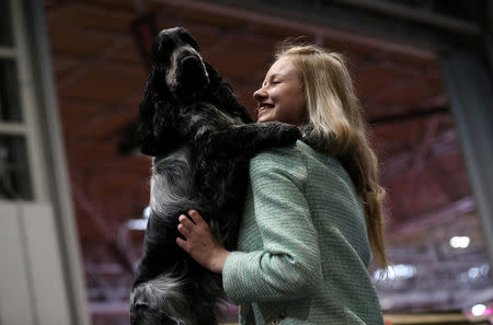 A woman cuddles her Cocker Spaniel during the first day of the Crufts Dog Show in Birmingham, Britain, March 7, 2019. REUTERS/Hannah McKay