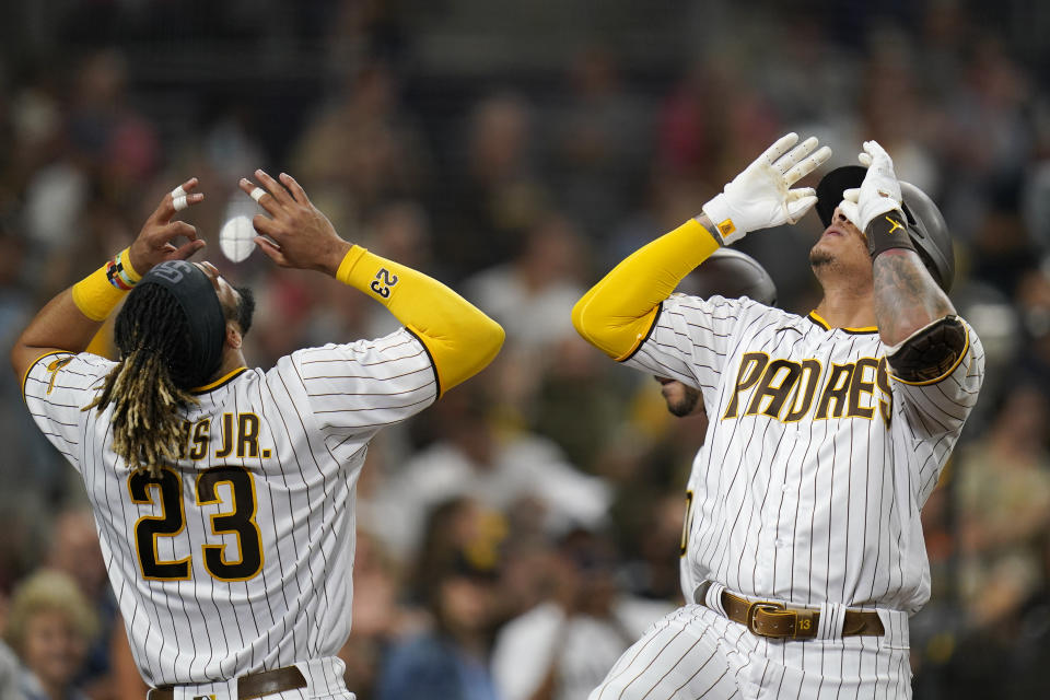 San Diego Padres' Manny Machado, right, celebrates with Fernando Tatis Jr. after hitting a two-run home run during the third inning of the team's baseball game against the Philadelphia Phillies, Friday, Aug. 20, 2021, in San Diego. (AP Photo/Gregory Bull)