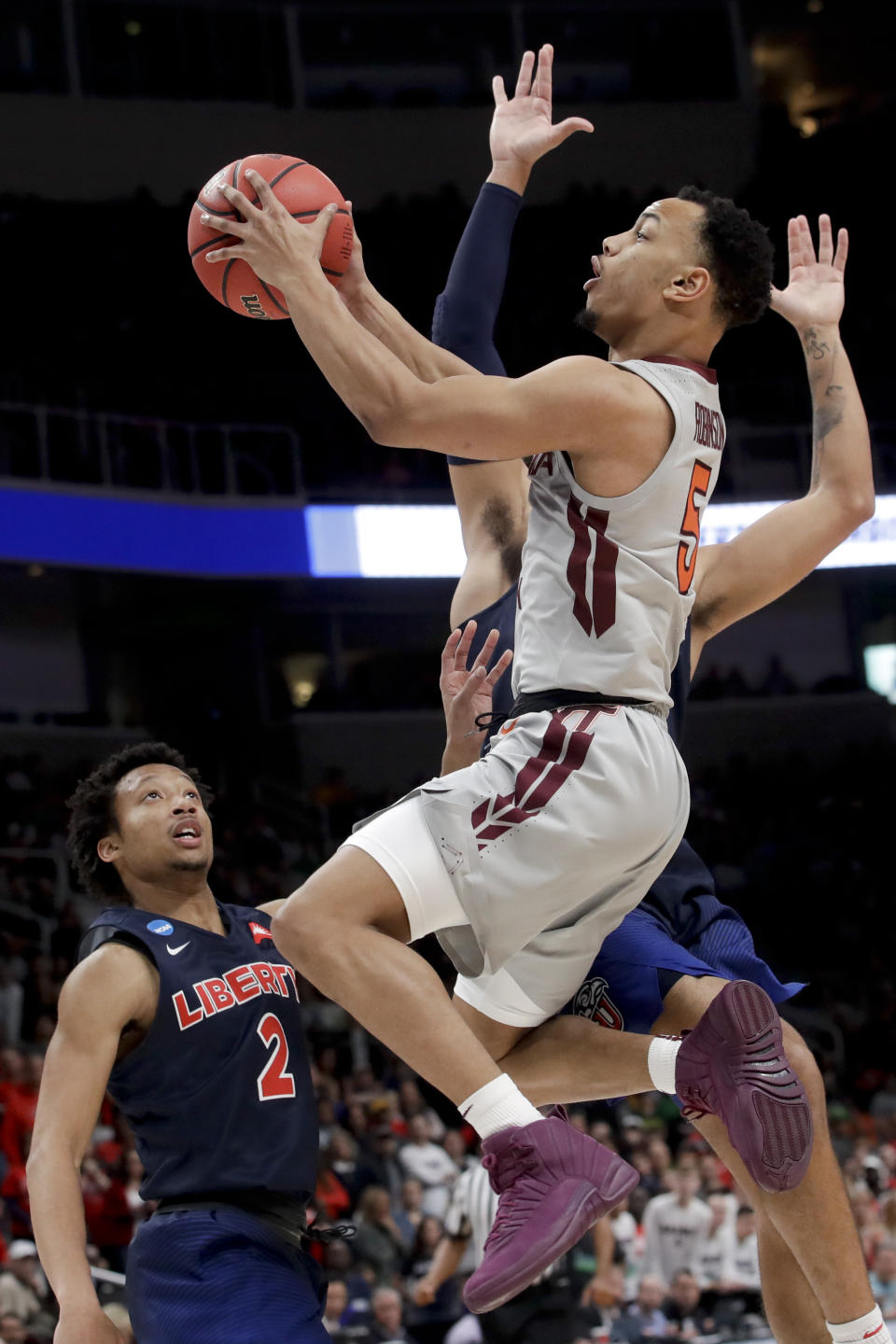 Virginia Tech guard Justin Robinson drives to the basket past Liberty guards Darius McGhee (2) and Elijah Cuffee during the second half of a second-round game in the NCAA men's college basketball tournament Sunday, March 24, 2019, in San Jose, Calif. (AP Photo/Jeff Chiu)