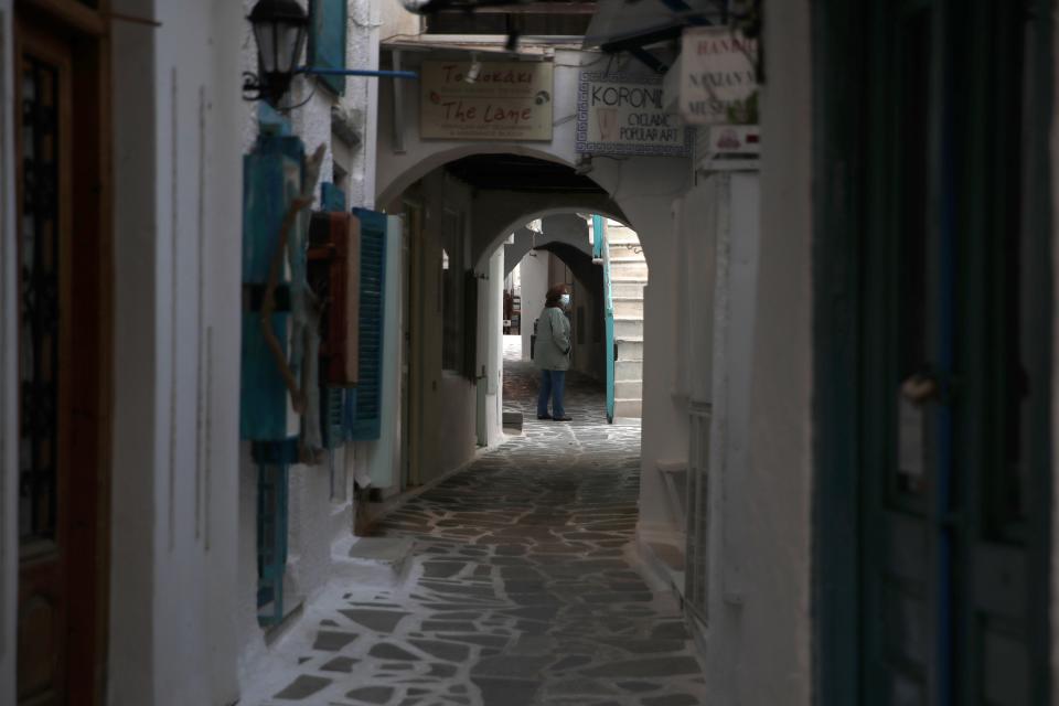 A woman wearing a face mask to help curb the spread of the coronavirus, walks at the old market in Chora, on the Aegean island of Naxos, Greece, Thursday, May 13, 2021. (AP Photo/Thanassis Stavrakis)