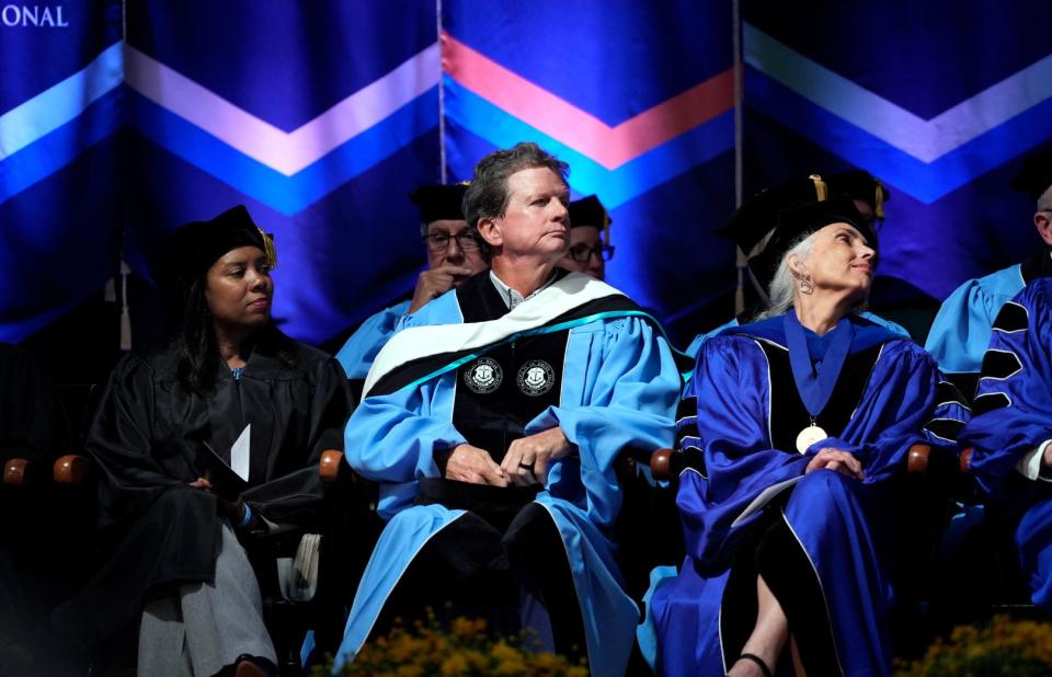 Board of Trustees member Thomas Ryan, center, listens from the stage with other VIPs at the inauguration ceremony on Thursday.