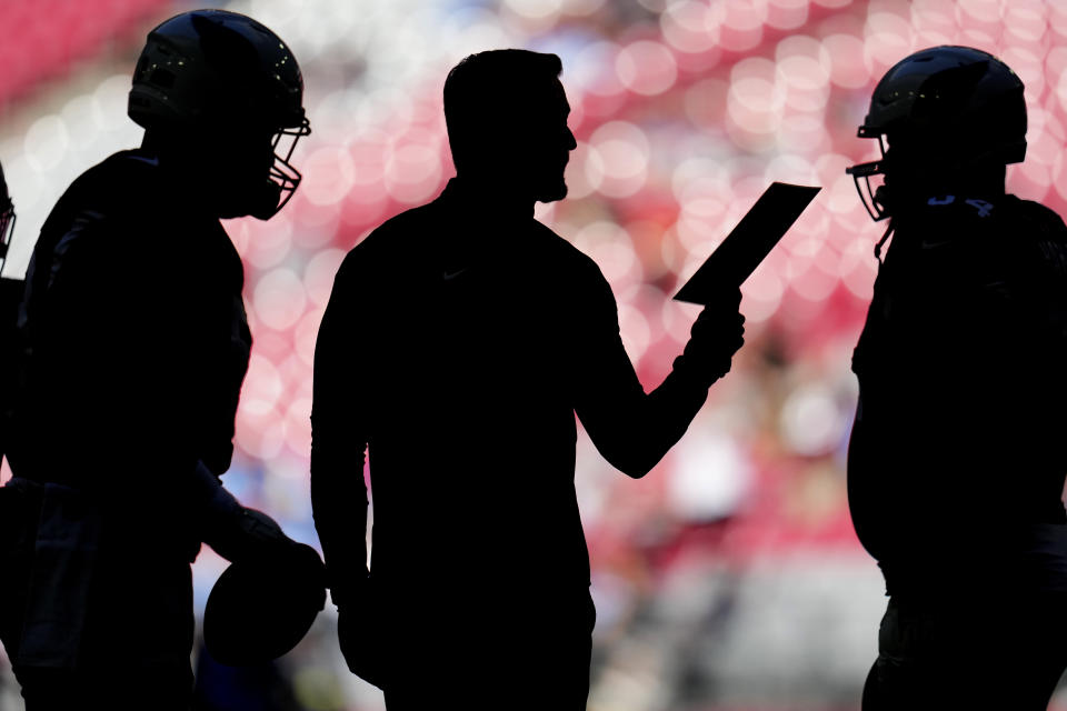 Arizona Cardinals head coach Kliff Kingsbury, center, speaks with players during the first half of an NFL football game against the Los Angeles Chargers, Sunday, Nov. 27, 2022, in Glendale, Ariz. (AP Photo/Ross D. Franklin)