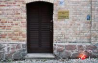 The flowers and candles are seen next to the damaged door of a synagogue in Halle