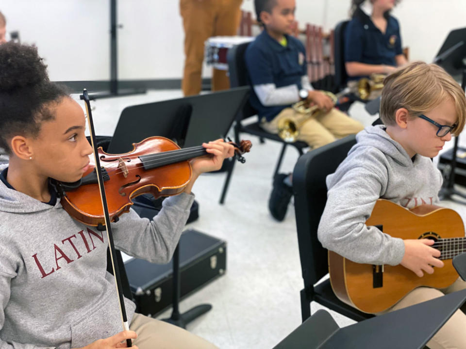 Washington Latin students McKensie and Eamonn play their instruments during a regular “arts block.” (Andrew Brownstein/The 74)