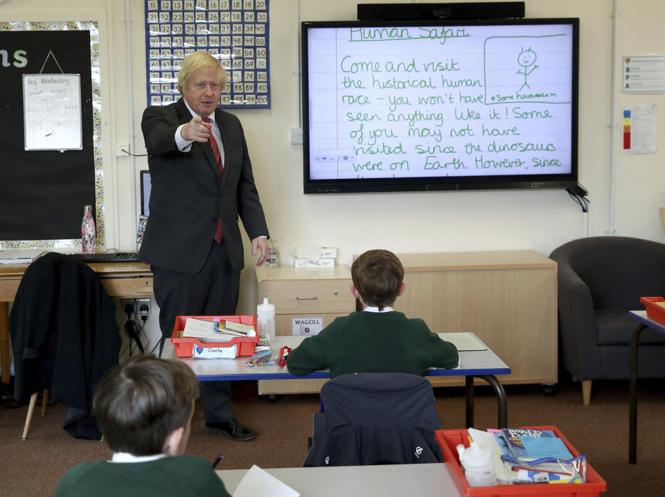 Britain's Prime Minister Boris Johnson joins a socially distanced lesson during a visit to Bovingdon Primary School in Bovingdon, Hemel Hempstead, England, Friday June 19, 2020. (Steve Parsons/Pool via AP)